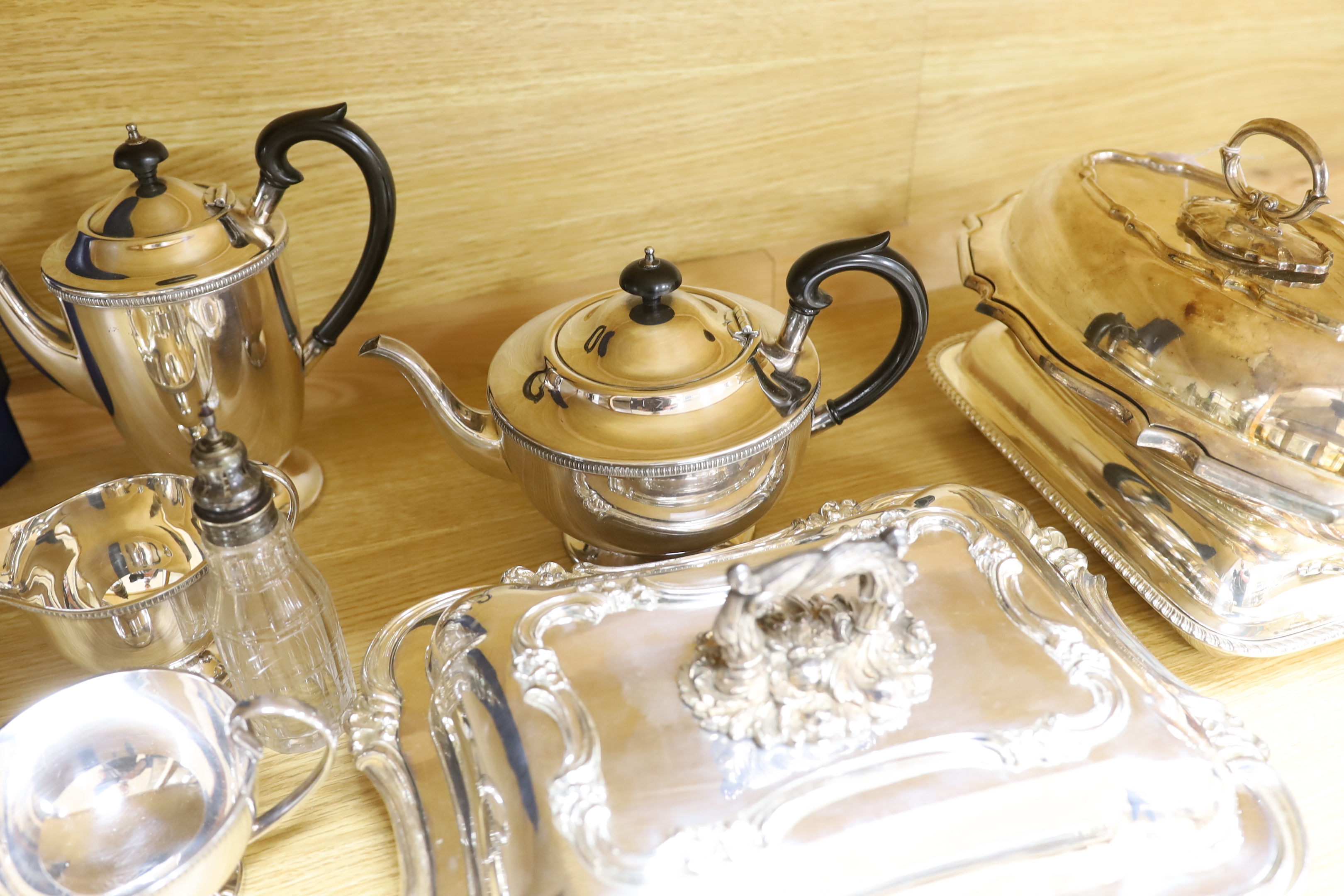 A quantity of silver plate including tea and coffee pots with ebonised handles and a pair of serving dishes
